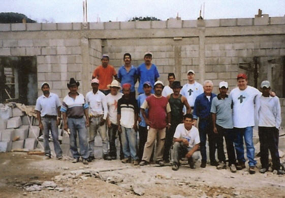 workmen in front of partially constructed clinic